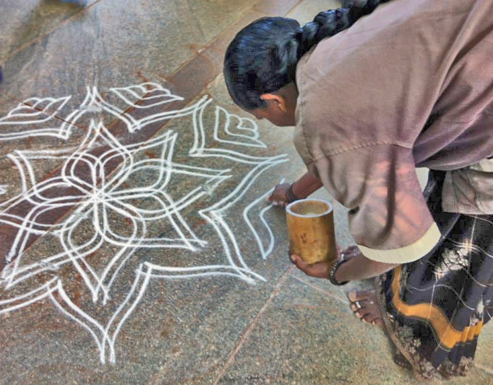 MUlher desenhando um Kolam na entrada da casa - Foto de Sylvia Leite - BLOG LUGARES DE MEMORIA