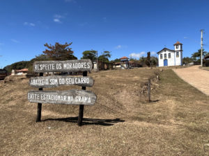 Placa pede silencio na praça de Curralinho com igreja ao fundo - Foto de Sylvia Leite - BLOG LUGARES DE MEMORIA