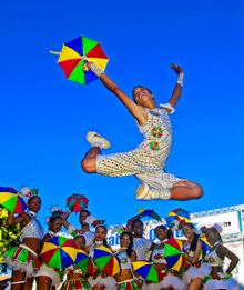 Passista de frevo com outros passistas ao fundo - Foto de Prefeitura de Olinda em Flickr e Wikimedia - CC BY 2 - BLOG LUGARES DE MEMORIA